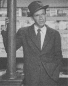 blurry old black and white photo of a man wearing a suit and hat