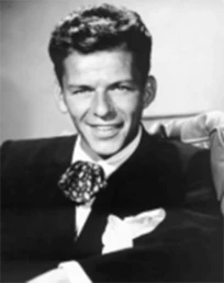 old black and white photo of a man in a black suit smiling at the camera