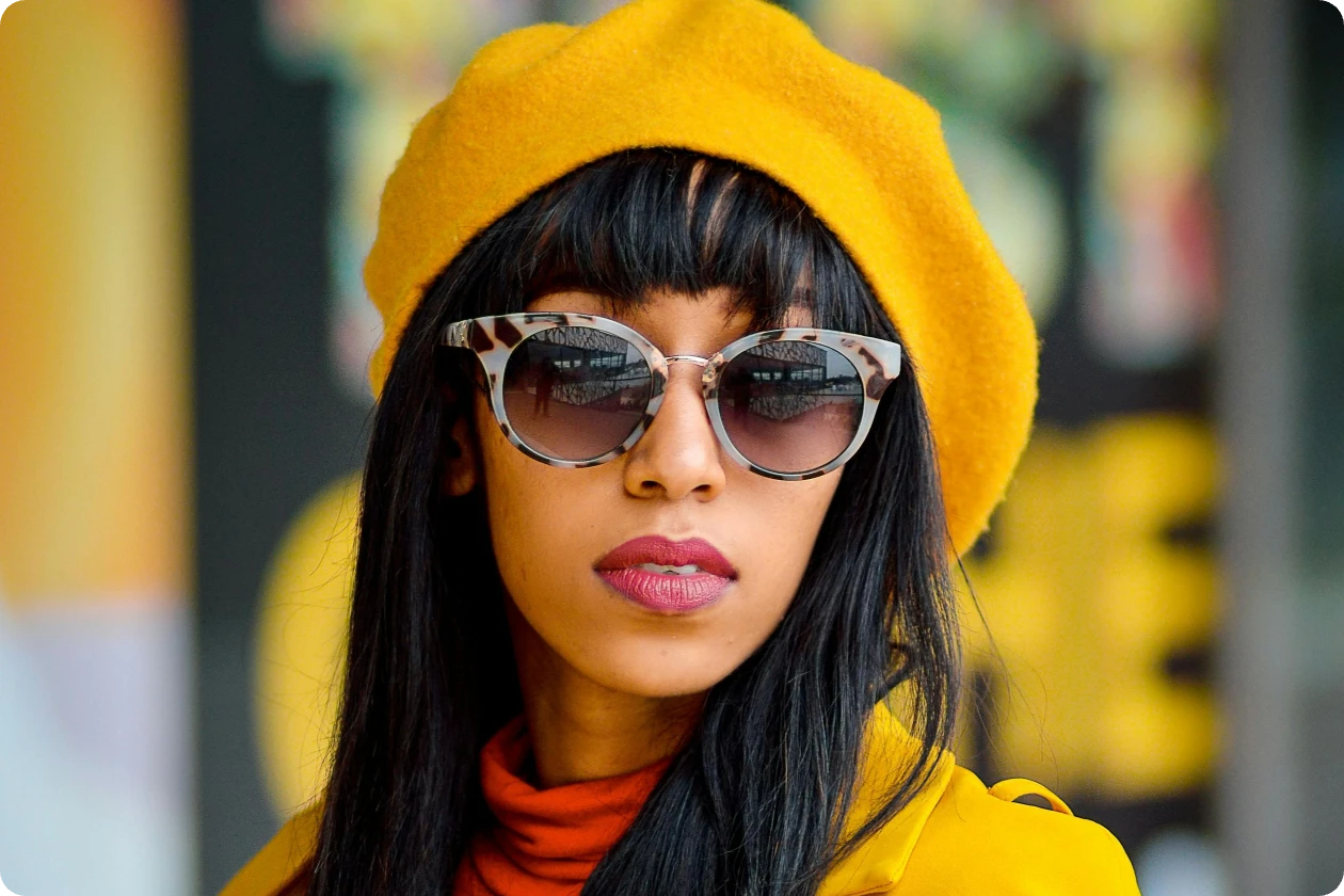 a woman with a yellow hat is virtually trying on a fashion glasses