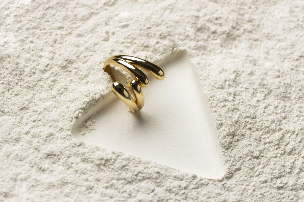 expensive golden ring with white powder background